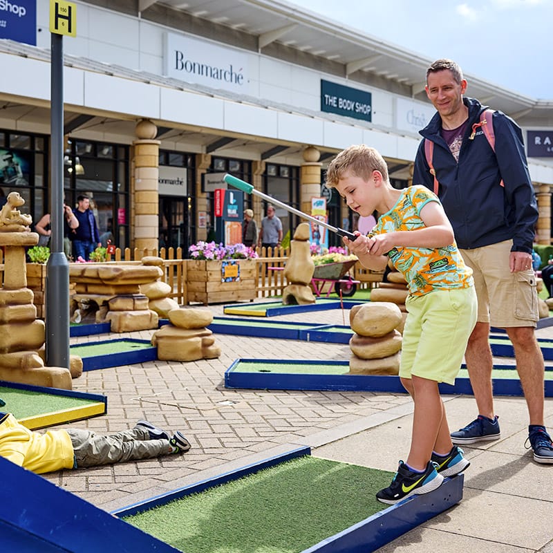 Lakeside Village father and son playing mini golf.